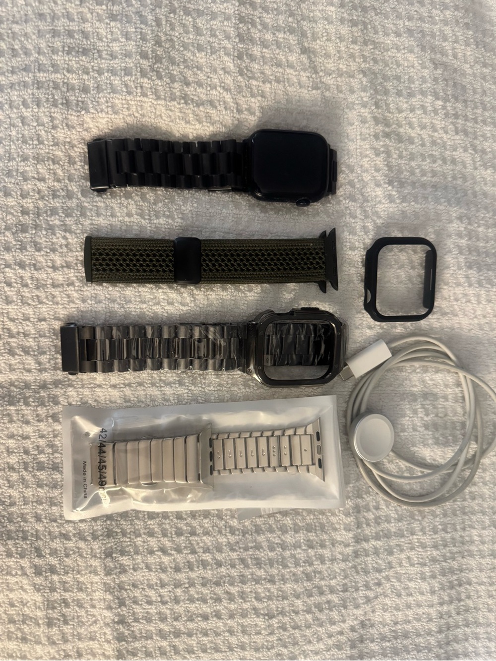Apple Watch series 11. face covering Charger Black Olive Green and silver bands